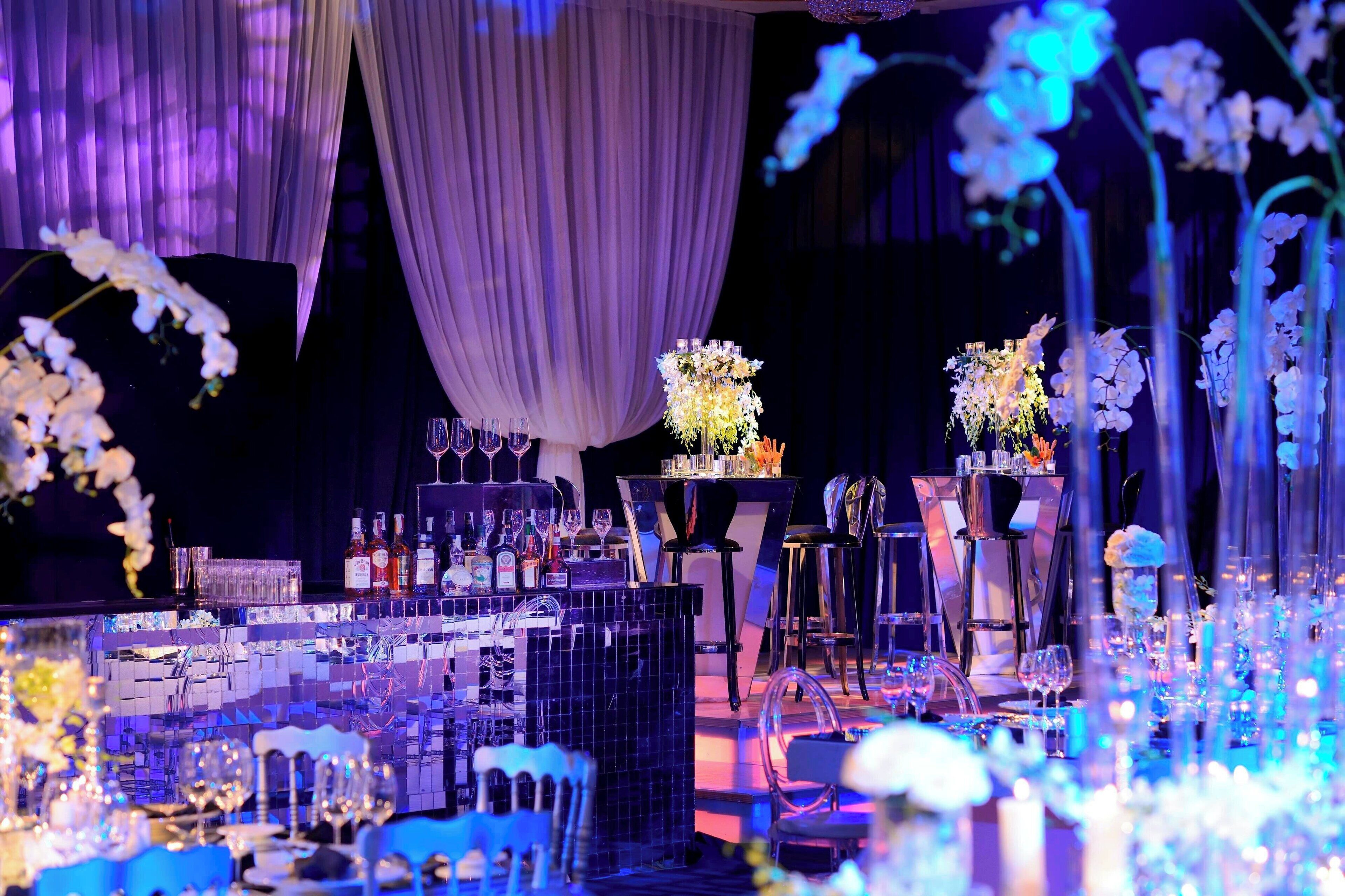 A formal event setup with tables, chairs, and floral decorations.