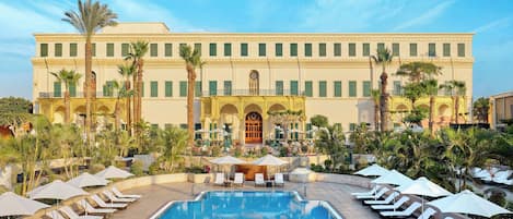 Alberca al aire libre, sombrillas en la alberca y camastros