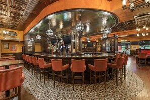 A bar area with a curved counter, multiple stools, and hanging light fixtures. - Best Western Plus Cobourg Inn & Convention Centre (Cobourg)