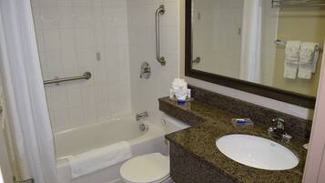 A bathroom with a bathtub, toilet, sink, and a mirror.