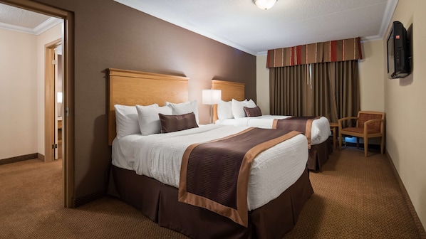 A hotel room with two beds, a flat-screen TV, a chair, and a door leading to another room.