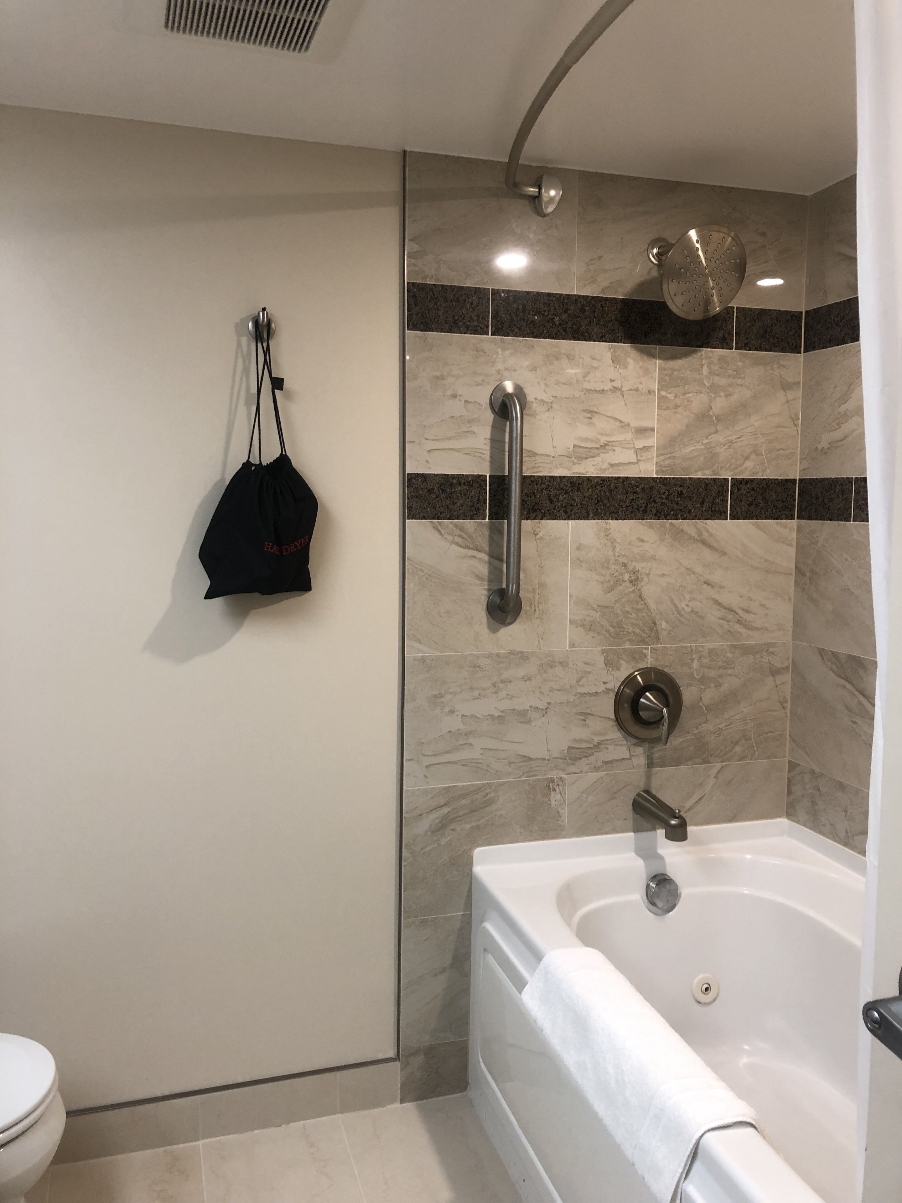 A modern bathroom with a walk-in shower, a bathtub, and a toilet.