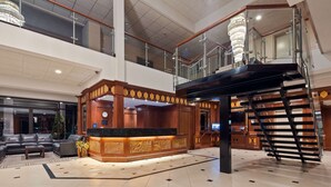A spacious lobby with a reception desk, a staircase, and a seating area. - Best Western Plus Cobourg Inn & Convention Centre (Cobourg)