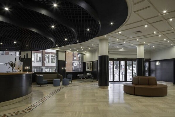 A modern lobby with a reception desk, seating area, and large windows. - Eurostars Indautxu (Bilbao)