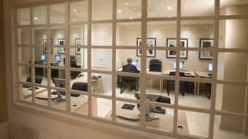 Un espacio de oficina moderno con varios puestos de trabajo, cada uno equipado con una computadora y una silla.