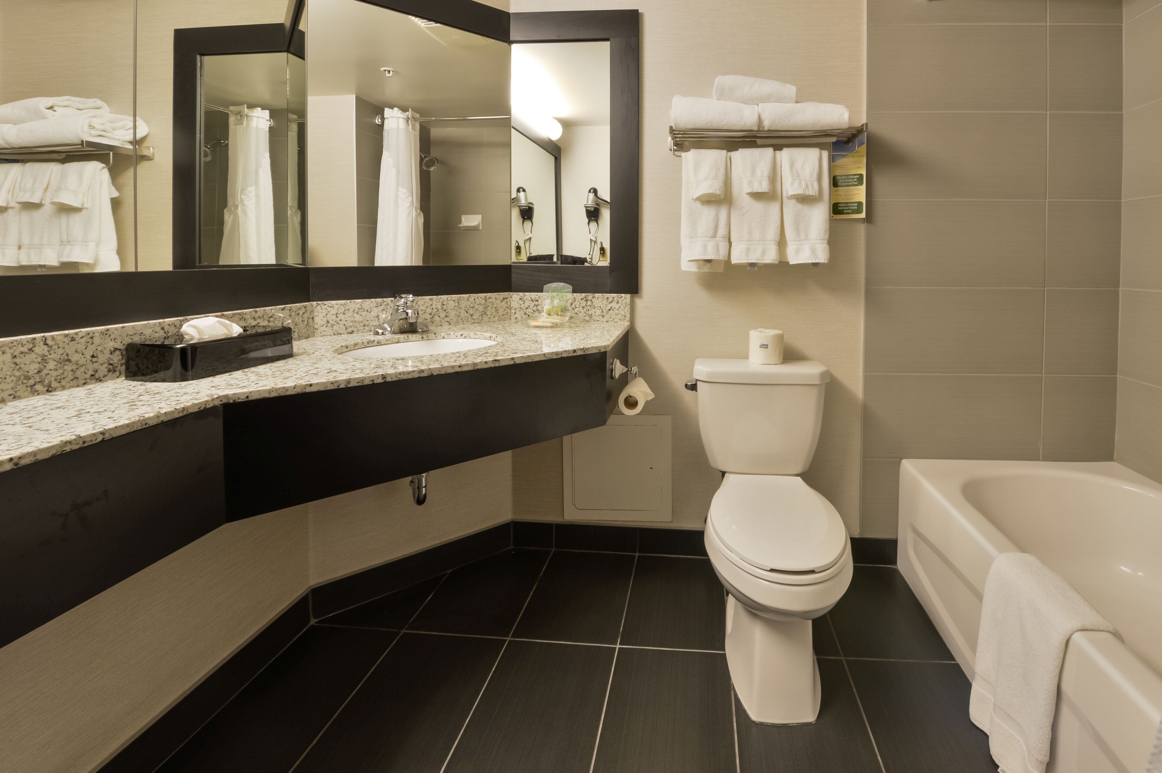 A modern bathroom with a sink, toilet, and bathtub.