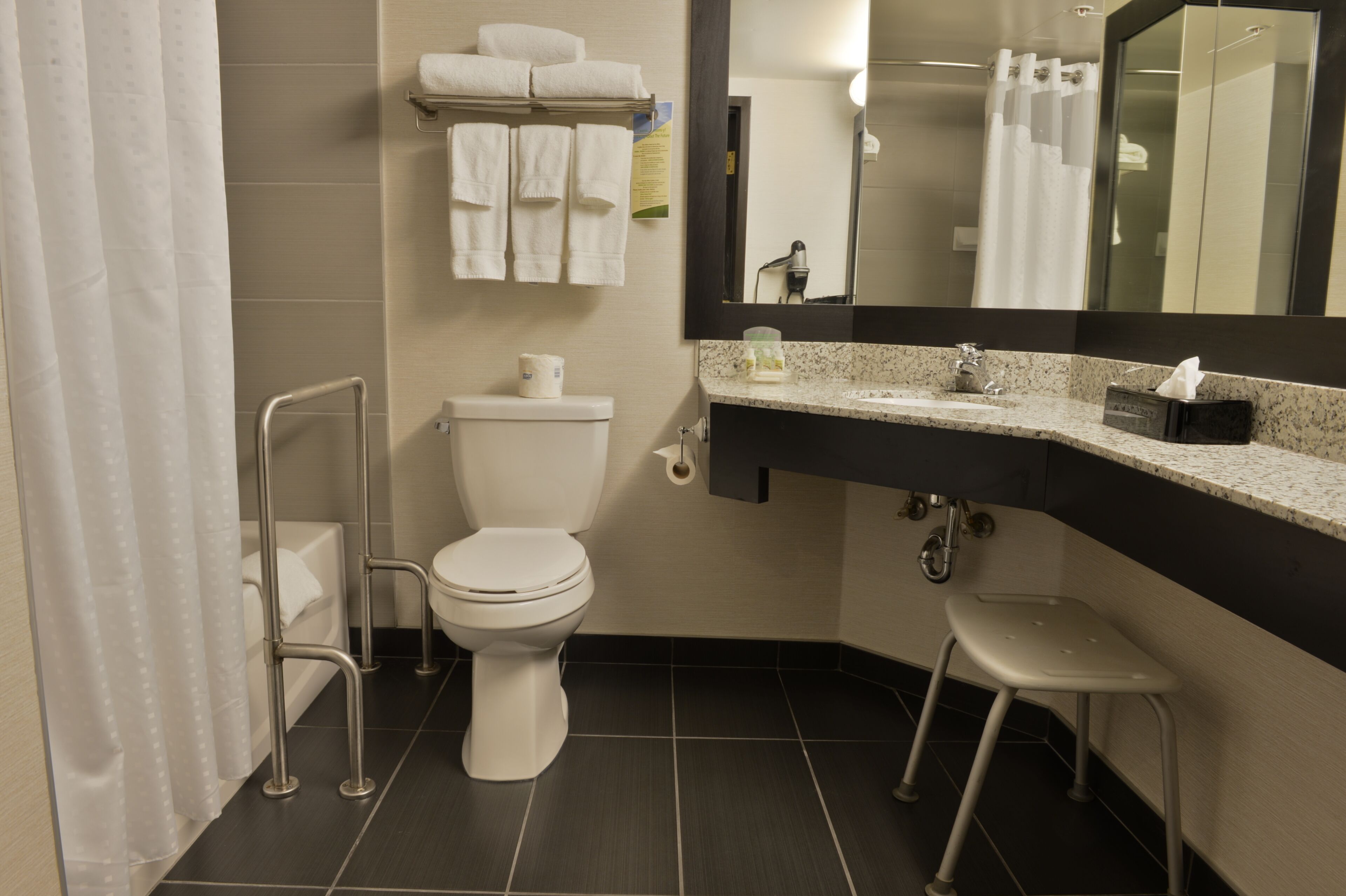 A modern bathroom with a toilet, a sink, a mirror, and a shower curtain.