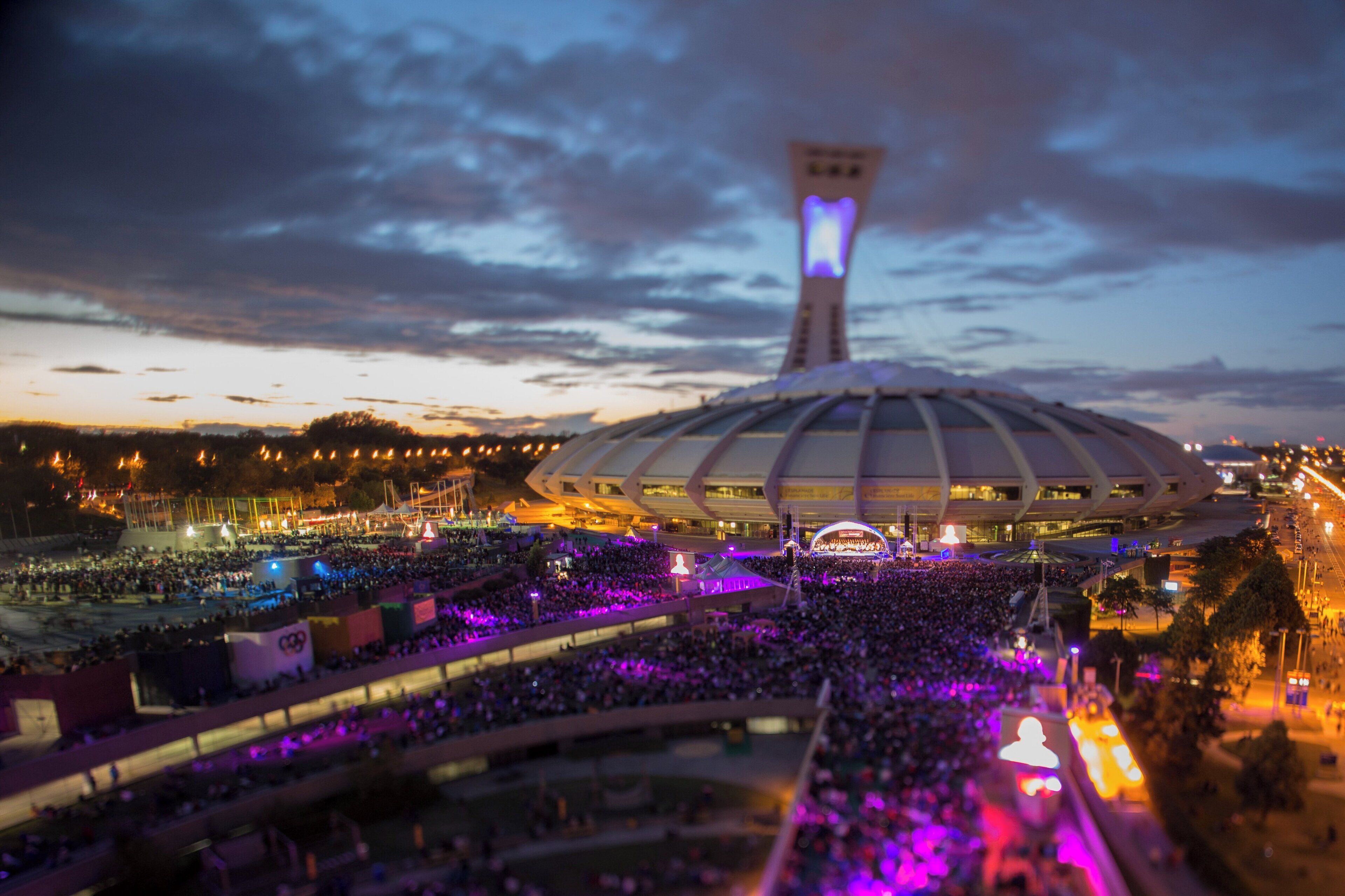 A stadium with a large crowd and a prominent tower structure.