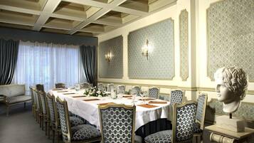 A formal dining room with a long table set for a meal, surrounded by upholstered chairs with a patterned design.