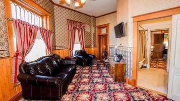 Habitación individual Deluxe | Área de sala de estar | Televisión