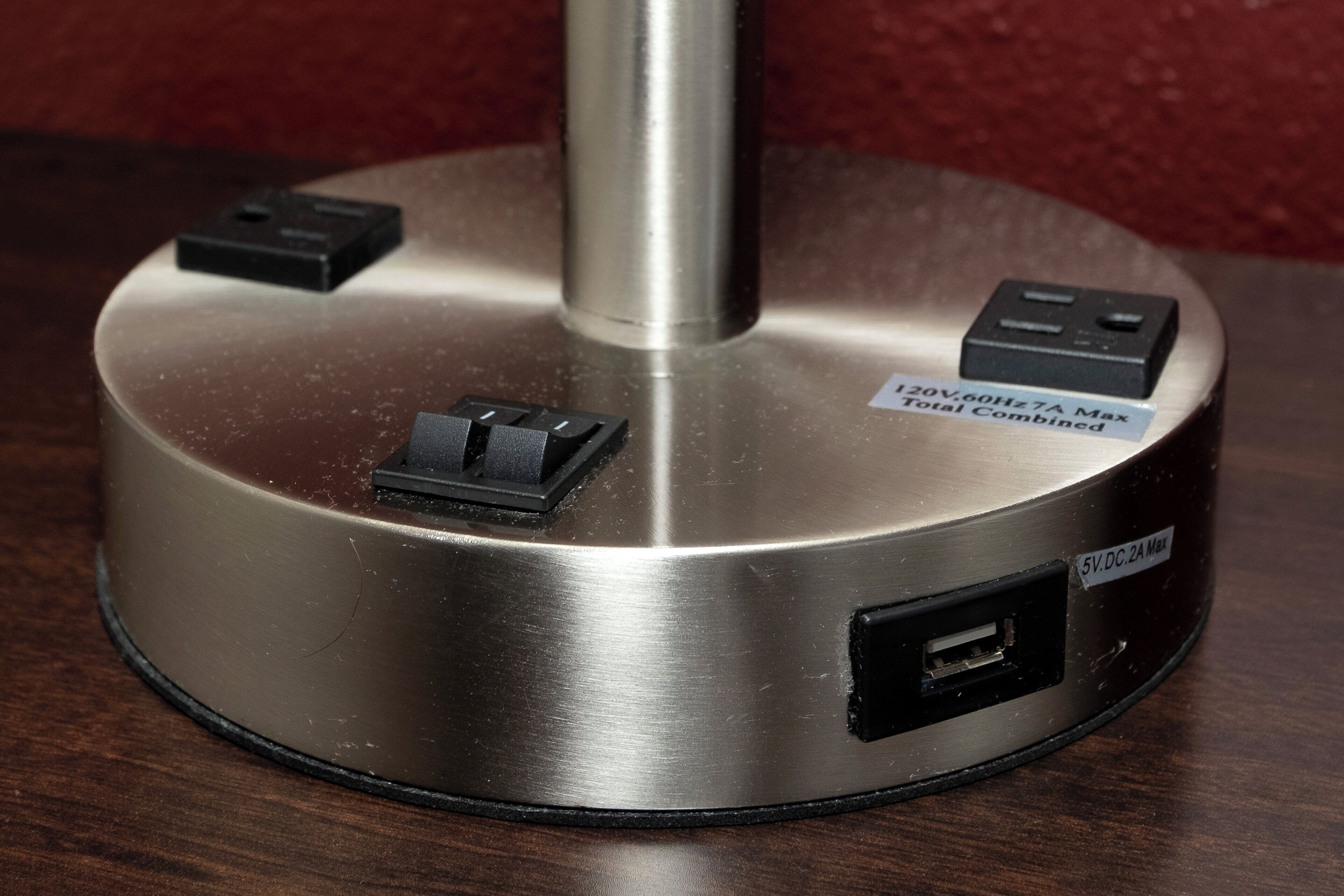 Una regleta con varios enchufes y un puerto USB sobre una superficie metálica.
