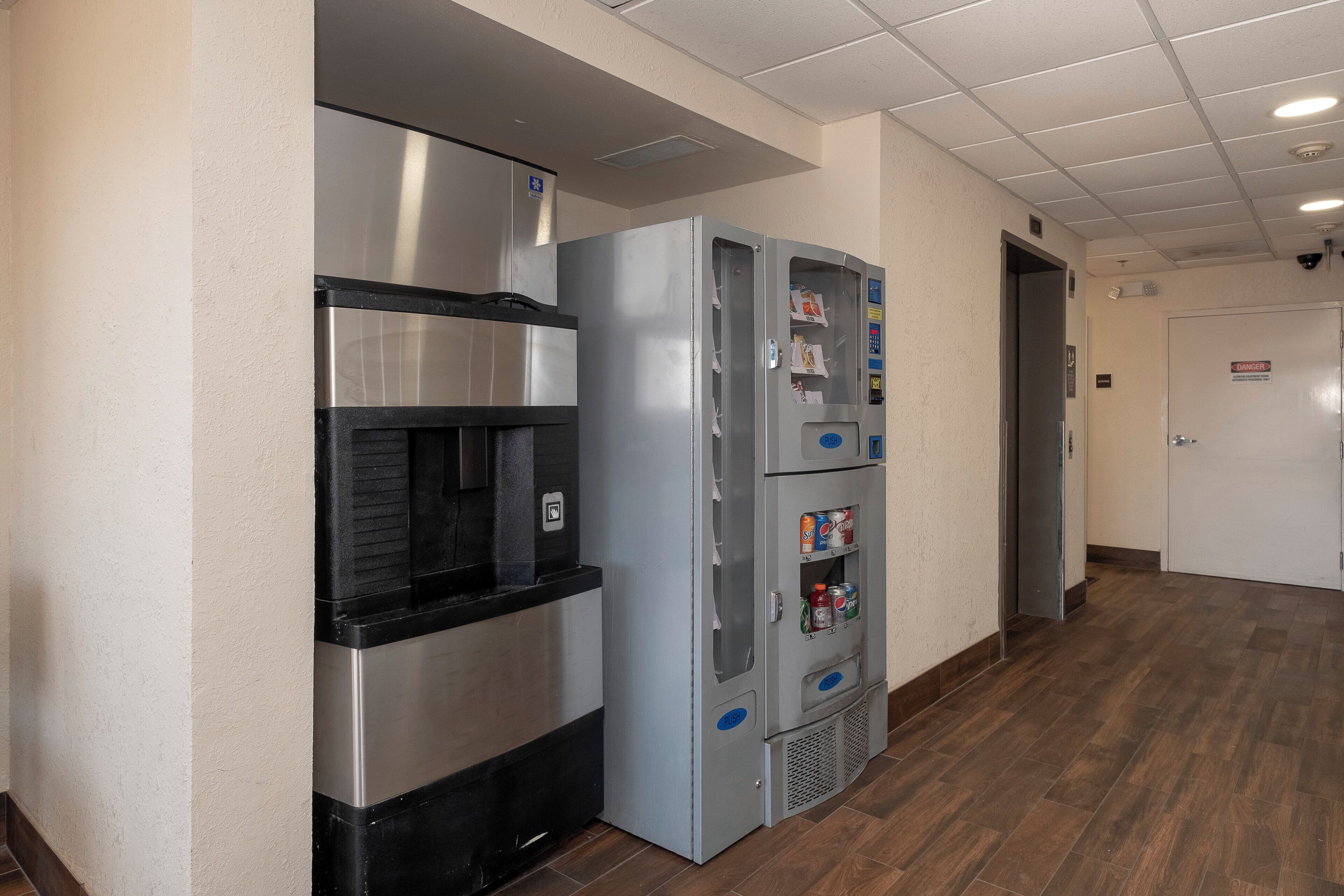 A commercial kitchen area with stainless steel appliances, including a refrigerator and a water dispenser.