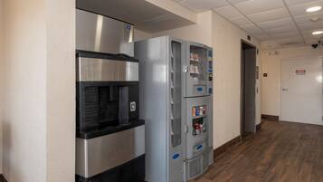 A commercial kitchen area with stainless steel appliances, including a refrigerator and a water dispenser.