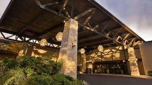 A building with a covered entrance, stone pillars, and a series of windows. - Seattle Airport Marriott (SeaTac)