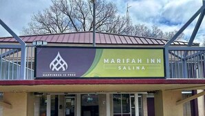 Een Marifah Inn Salina bord met een logo, de slogan 'Happiness is Free' en een bord met de tekst 'Must Visit'.
