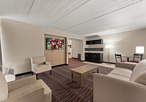 Relax in a spacious room with a comfortable seating area, flat-screen TV, and kitchenette.