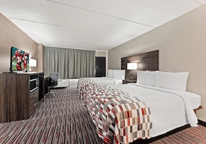 A hotel room with a large bed, a desk with a chair, a television, and a window with curtains. - Red Roof Inn Reading (Reading)