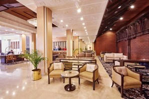 A hotel lobby with a reception desk, seating areas, and a chandelier. - The Everest Hotel Kathmandu (Kathmandu)