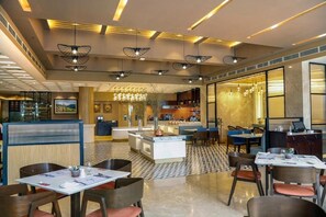 Un restaurant amb un terra de pissos, il·luminació penjant i una zona de bar.