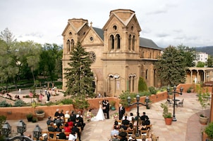 Una ceremonia de boda al aire libre con una iglesia histórica de fondo.
