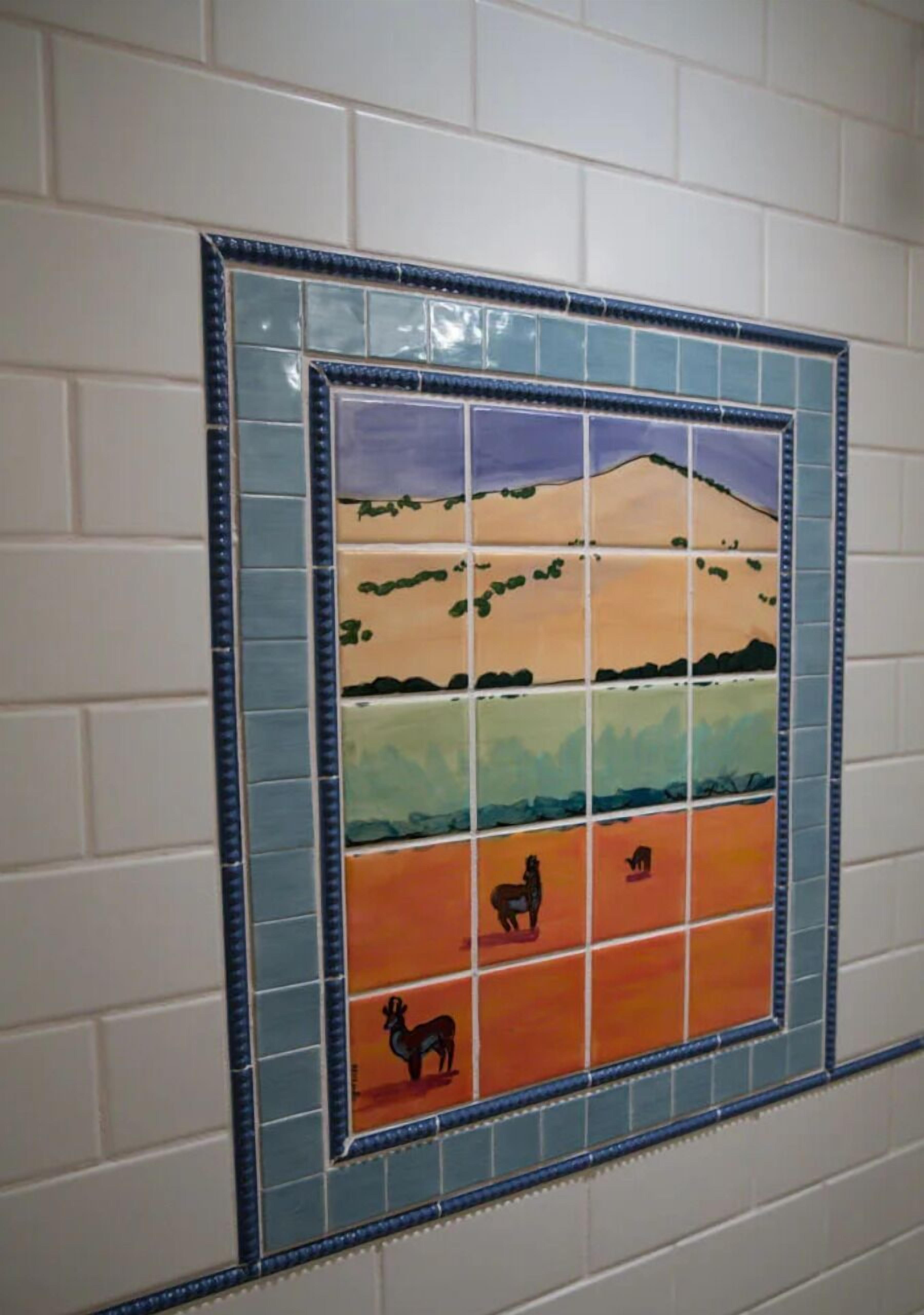 A mosaic tile wall with a landscape scene.