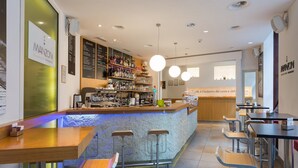 Un espace bar moderne avec un comptoir, des tabourets et un tableau affichant le menu.