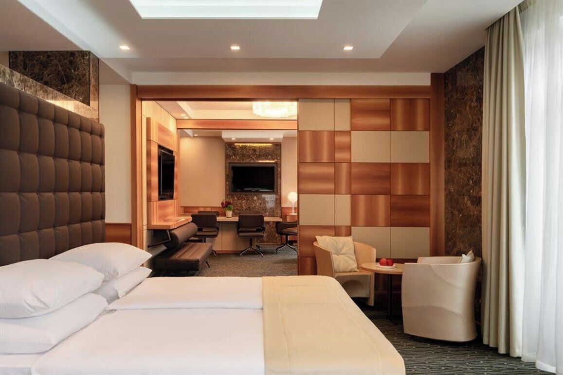 Una habitación de hotel con una cama grande, un escritorio, una silla y un televisor.