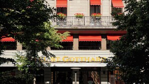 A building with multiple windows, some with red awnings, and a sign that reads 'HOTEL'. - St Gotthard Hotel (Zürich)