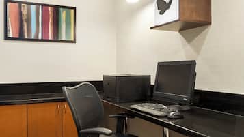 A modern office space with a desk, computer, printer, and a chair.