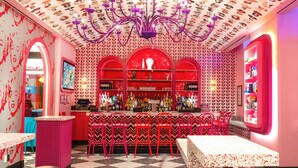 A bar area with a checkered floor, red and white patterned walls, and a chandelier. - OYO Times Square (New York)