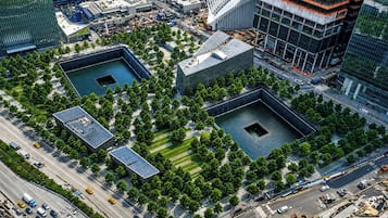 Vista aérea de un paisaje urbano con edificios modernos, una plaza central con árboles y una gran plaza.
