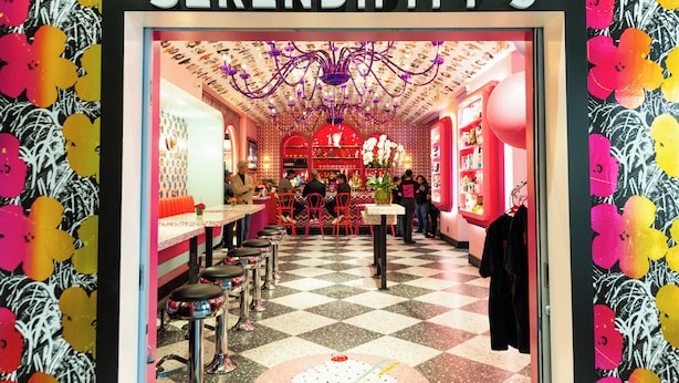 A vibrant interior of Serendipity 3 with a checkered floor, bar area, and colorful floral wallpaper. - OYO Times Square (New York)