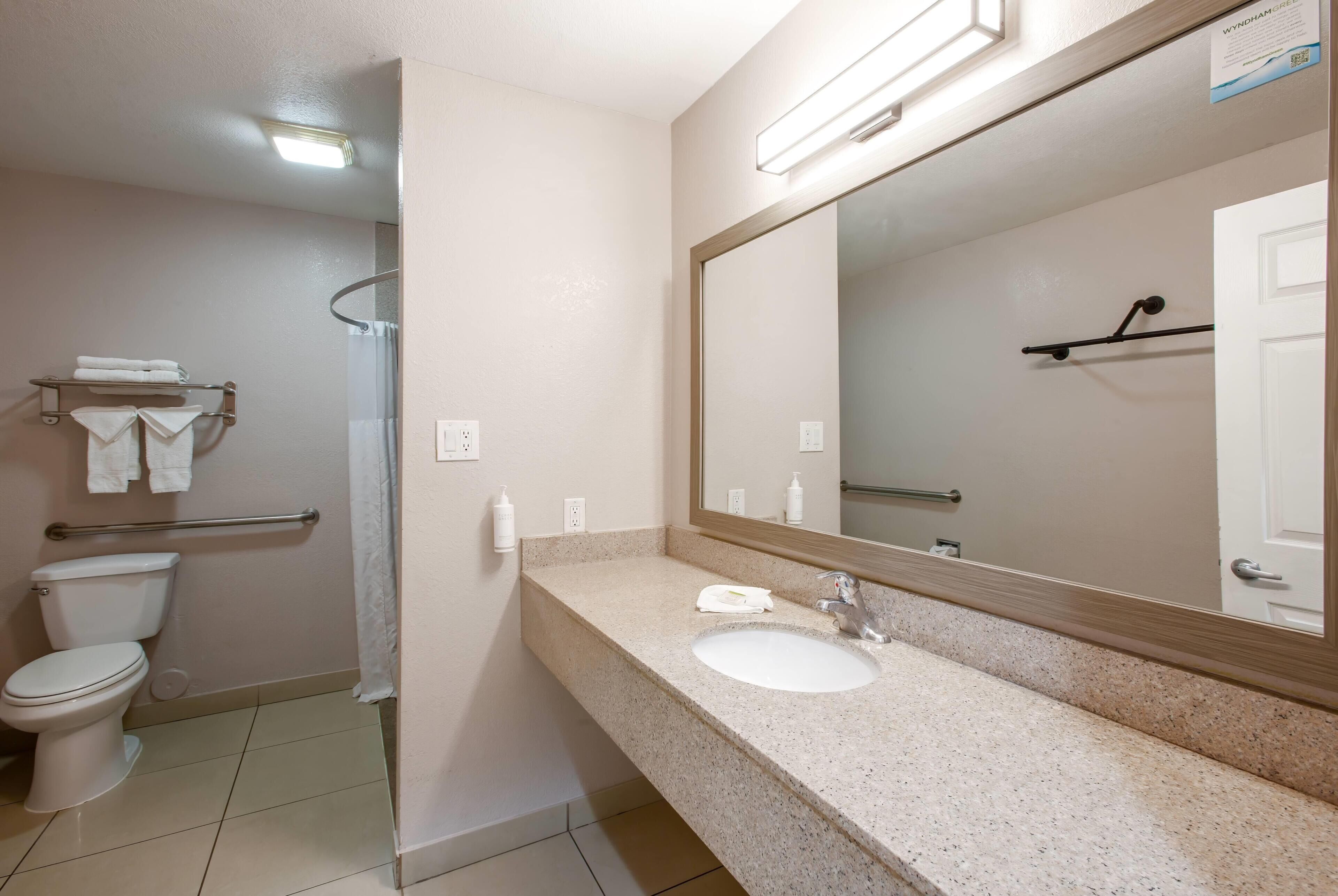 Une salle de bain avec des toilettes, un lavabo et un miroir.