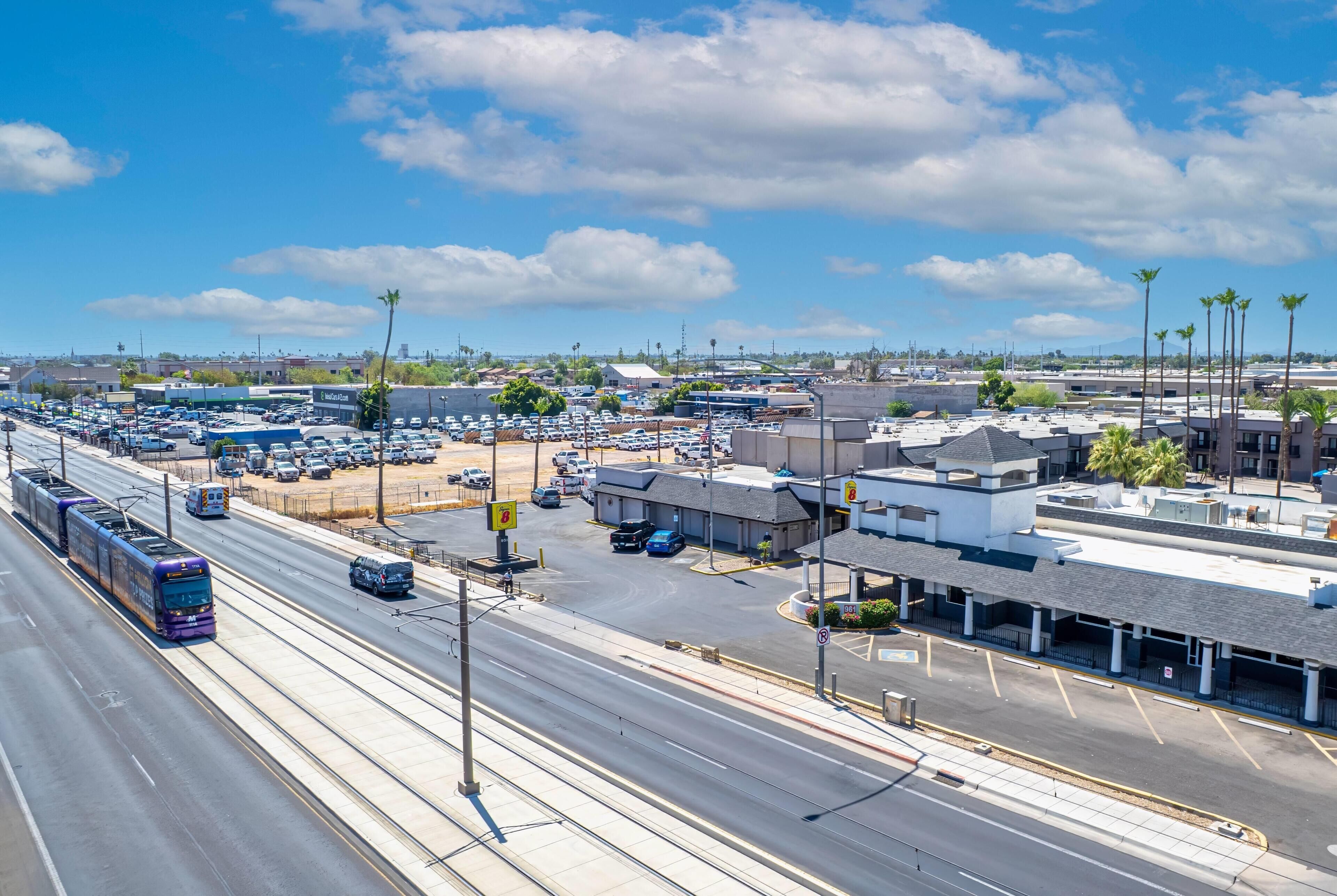 A multi-level parking structure with clear signage, a tram line, and a variety of buildings in the background.