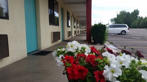 A motel with a row of rooms, a covered walkway, and a parking lot.
