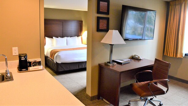 A hotel room with a bed, a desk with a chair, a TV, and a coffee maker. - Comfort Inn & Suites Beaverton - Portland West (Beaverton)