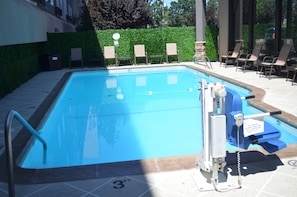 Piscine extérieure en saison, chaises longues