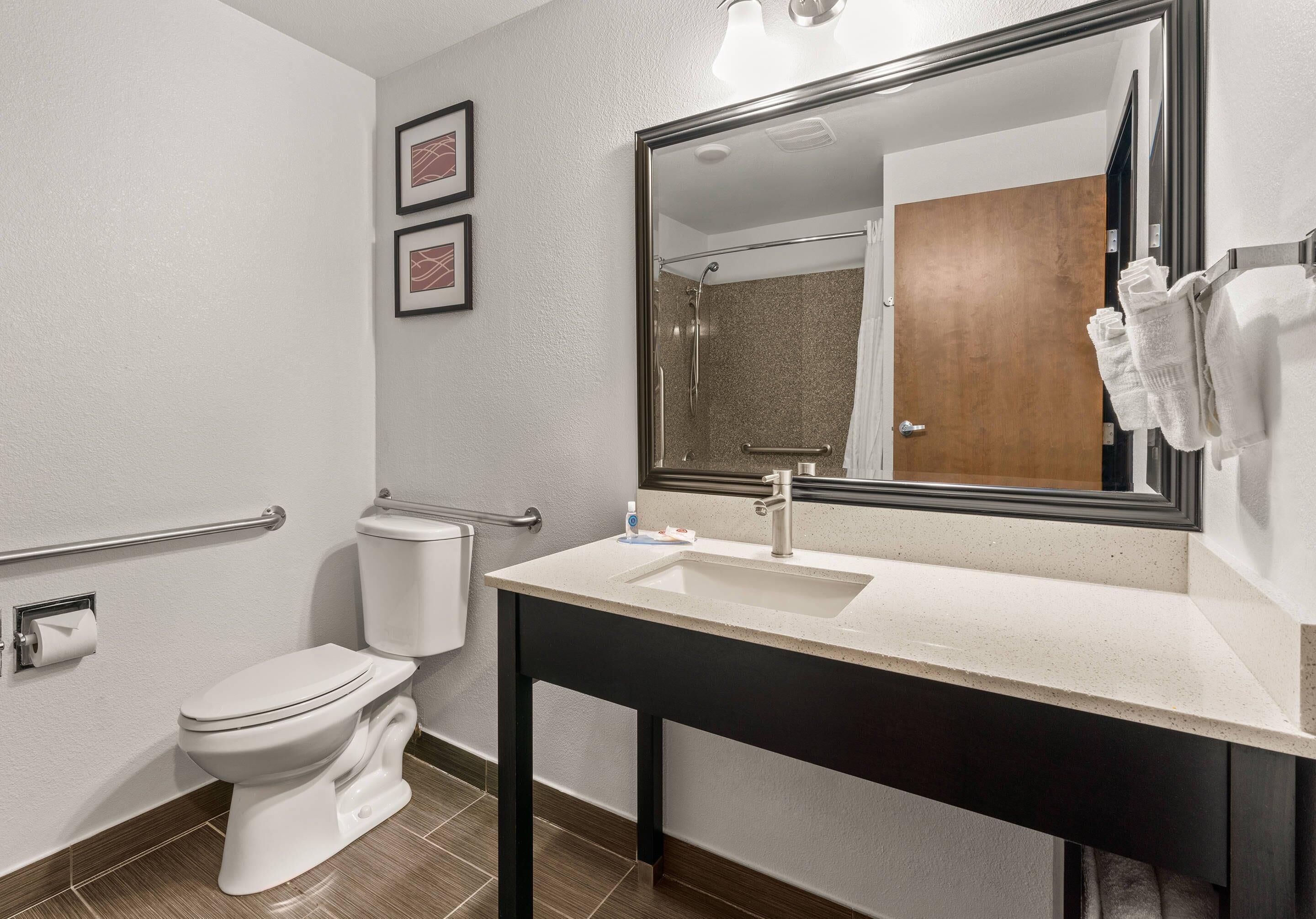 Un baño moderno con inodoro, lavamanos y ducha.