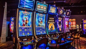 Une rangée de machines à sous aux thèmes variés, notamment « Le trône du griffon » et « Fonctionnalité bonus Wilds ».