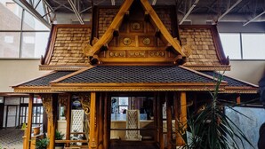 Il s’agit d’une structure traditionnelle en bois, dotée d’un toit en tuiles et d’éléments décoratifs, et qui fait probablement partie d’un bâtiment d’importance culturelle ou historique.