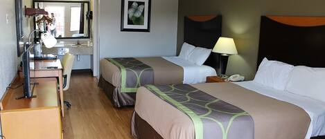 A hotel room with two beds, a desk, a chair, a mirror, and a framed picture on the wall.