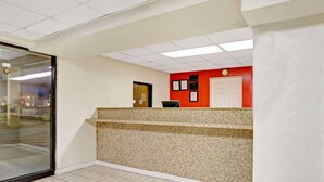 A reception area with a counter, a door, and a wall-mounted clock.
