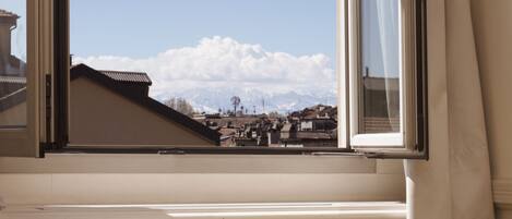 A room with a window overlooking a snowy mountain landscape.