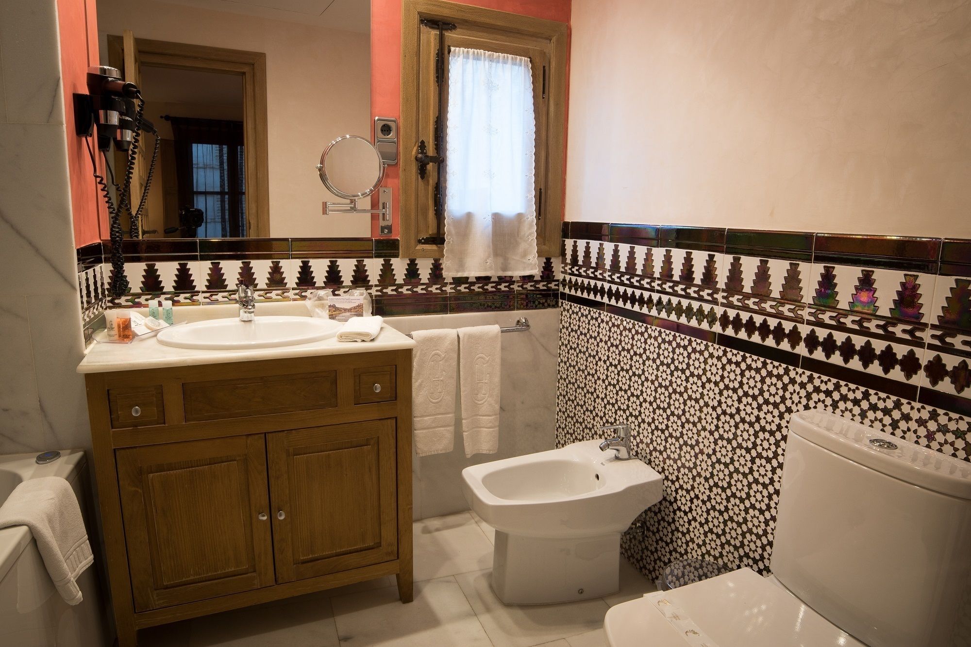 A bathroom with a wooden vanity, a bidet, and a toilet.