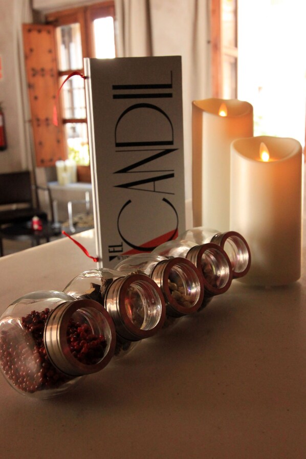 A candle holder with a label reading "CANDLE" and a lit candle in the background. - Hotel Pintor El Greco (Toledo)