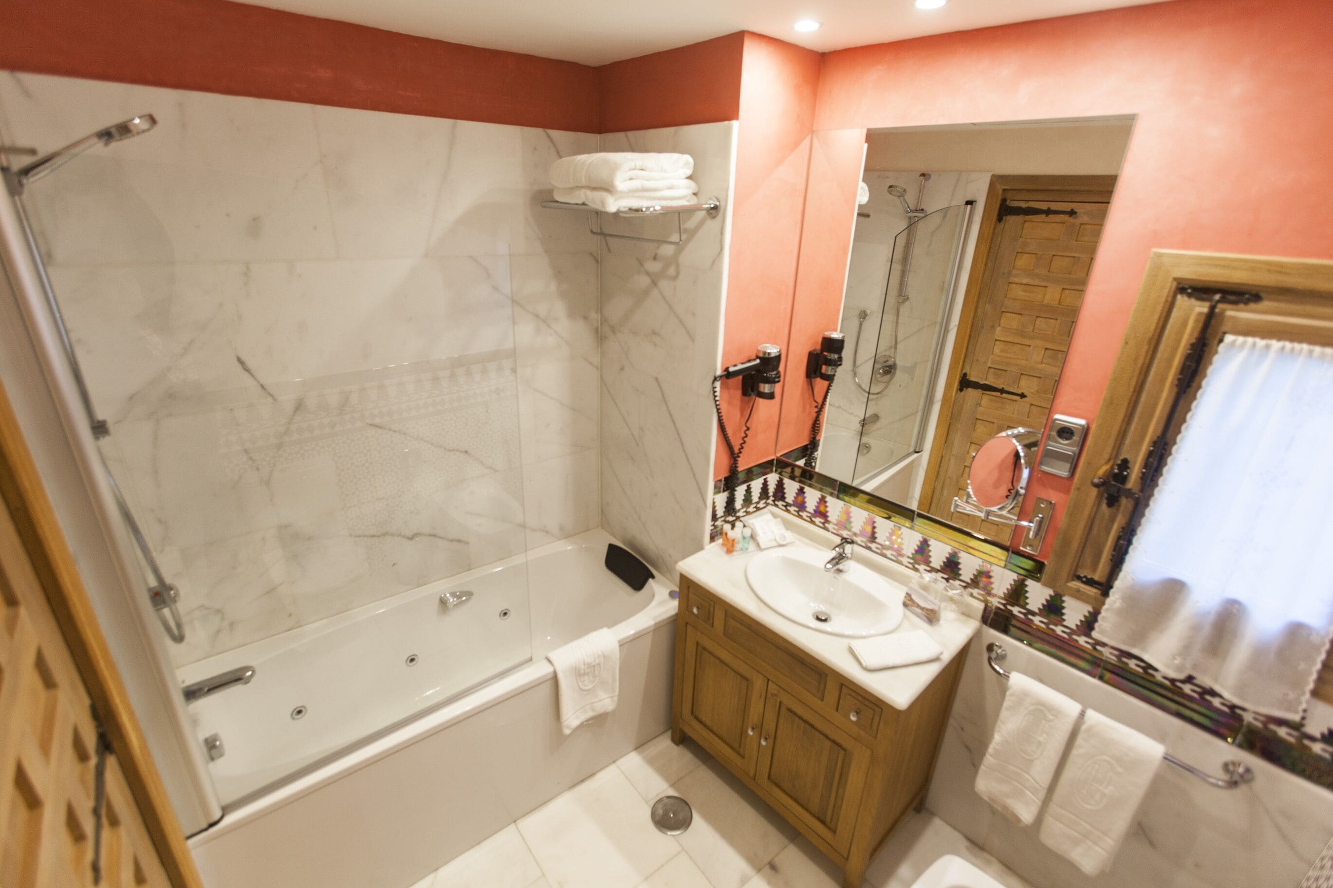 Un baño con bañera, lavamanos y espejo.