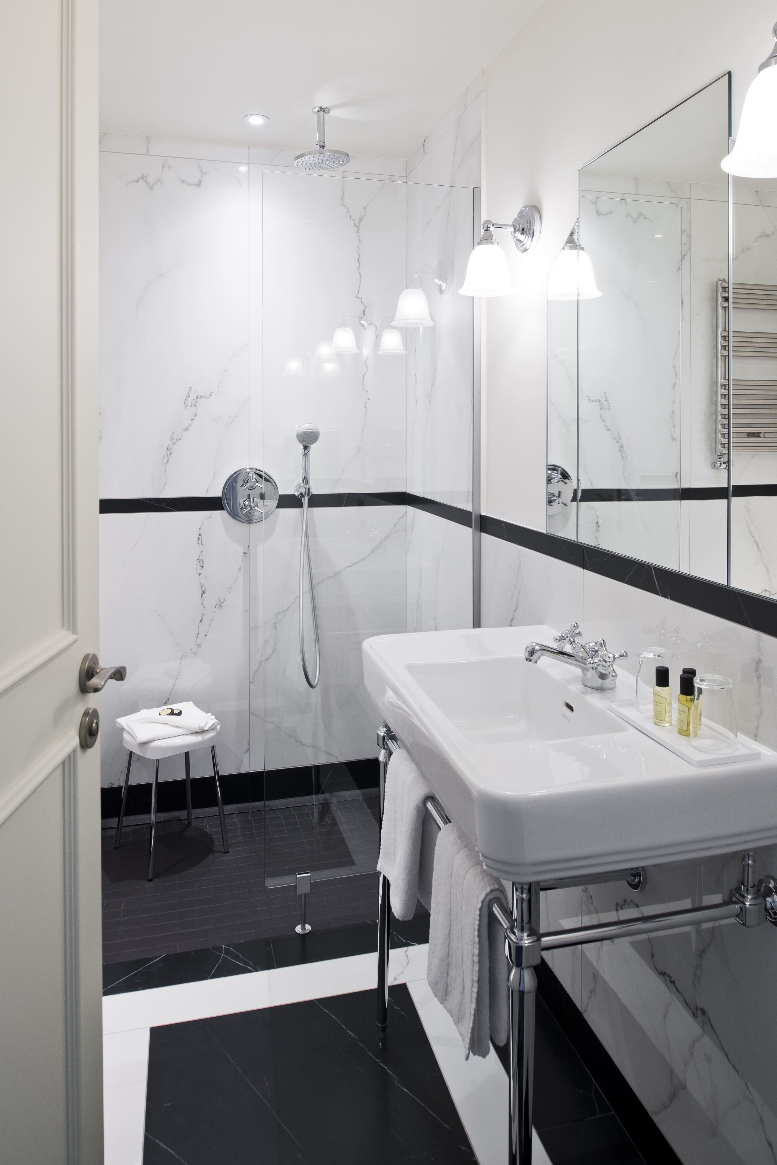 A modern bathroom with a white sink, a shower, and a mirror.