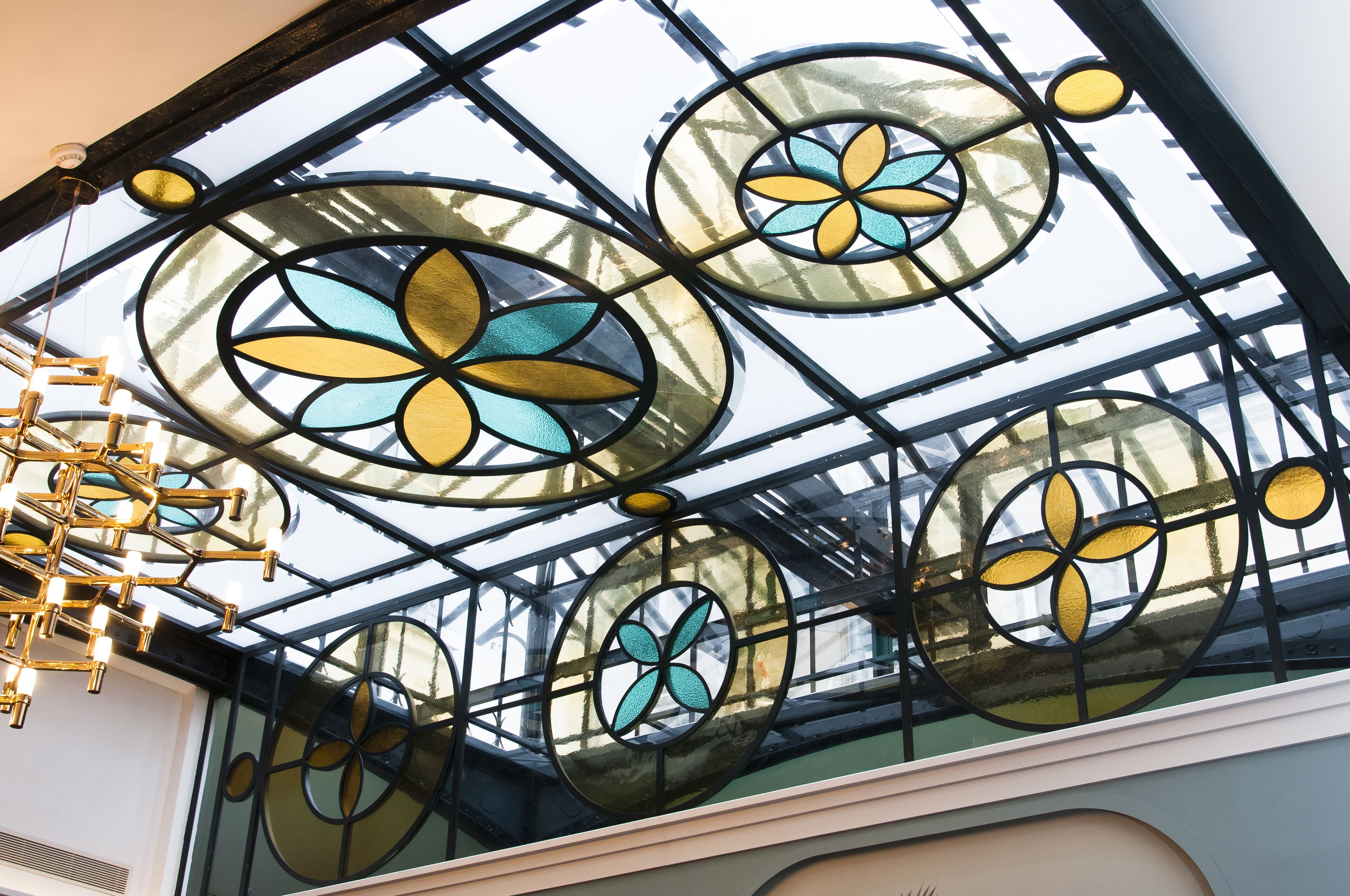 A ceiling with circular stained glass windows featuring floral designs.