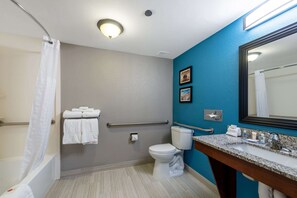 Bathroom features a bathtub, toilet, and sink with a granite countertop.