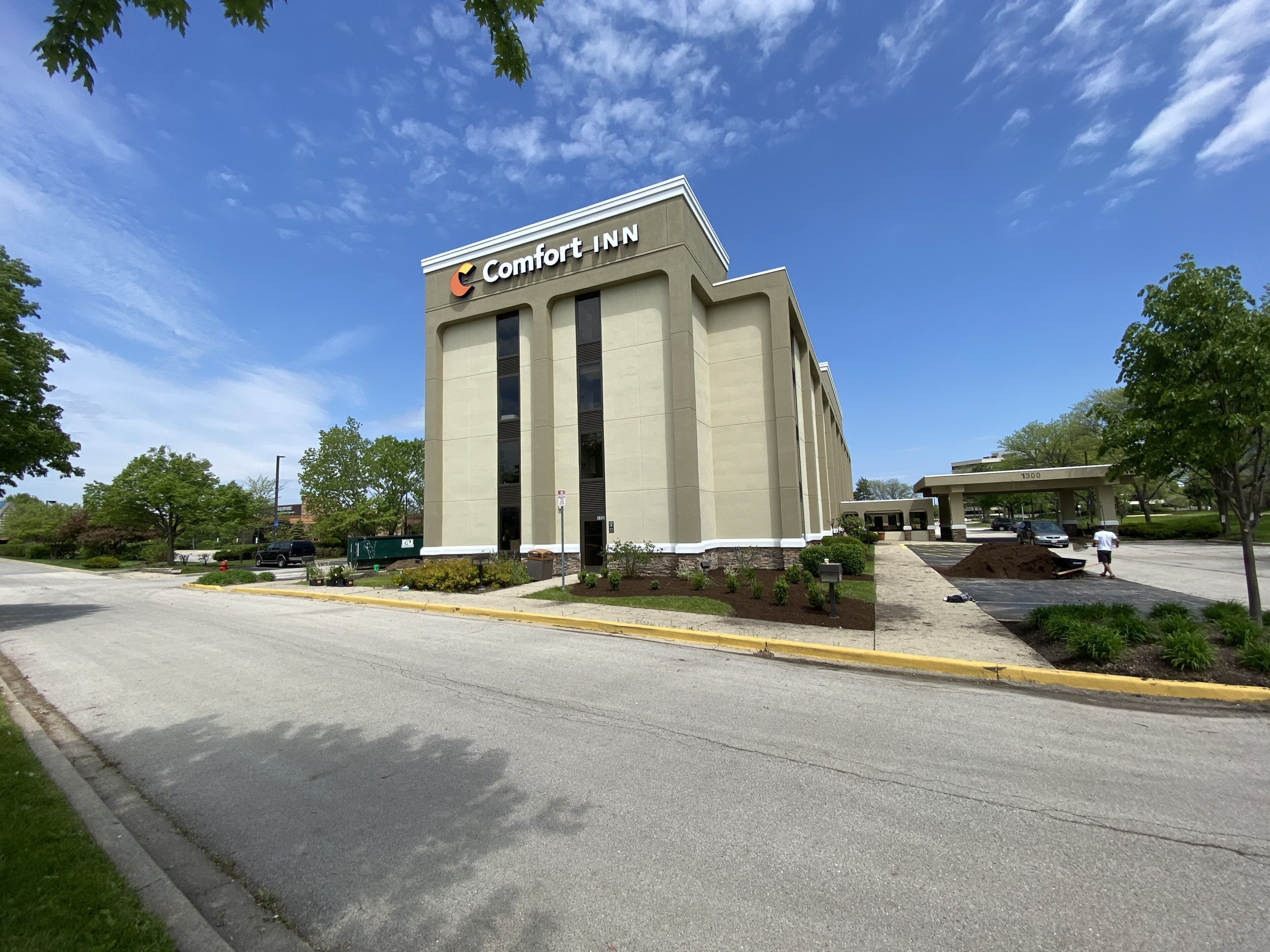A Comfort Inn hotel with a modern design, featuring a prominent entrance and a parking lot.